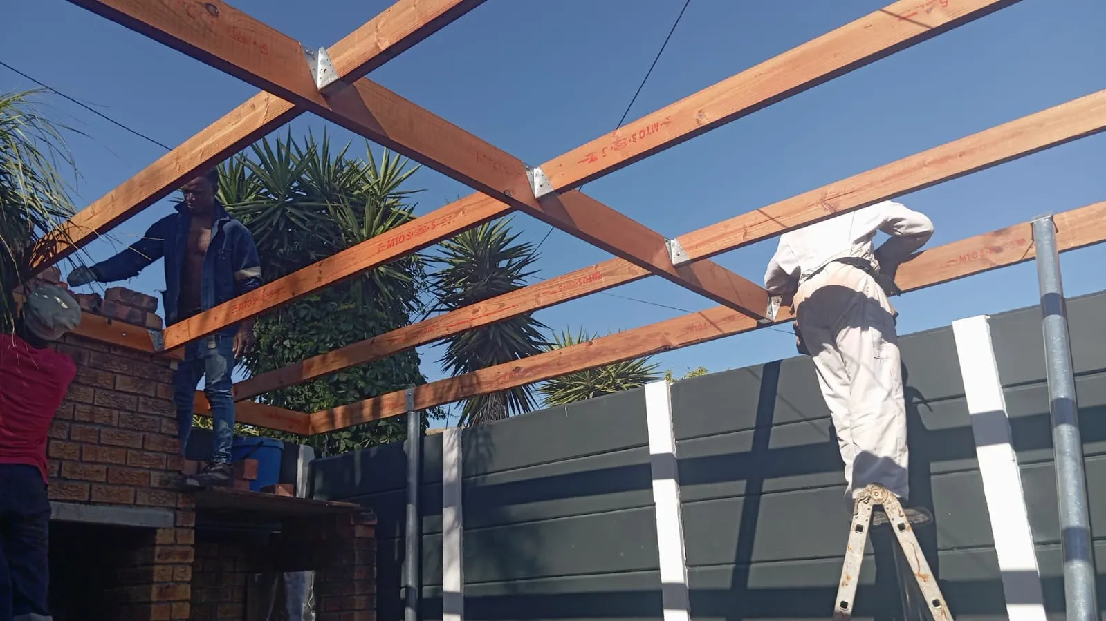 Team installing timber pergola beams