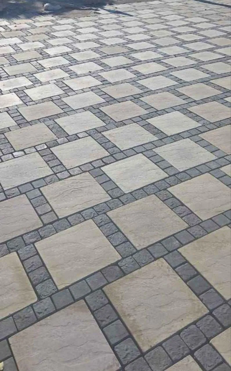 Sandstone pavers framed by charcoal brick bands