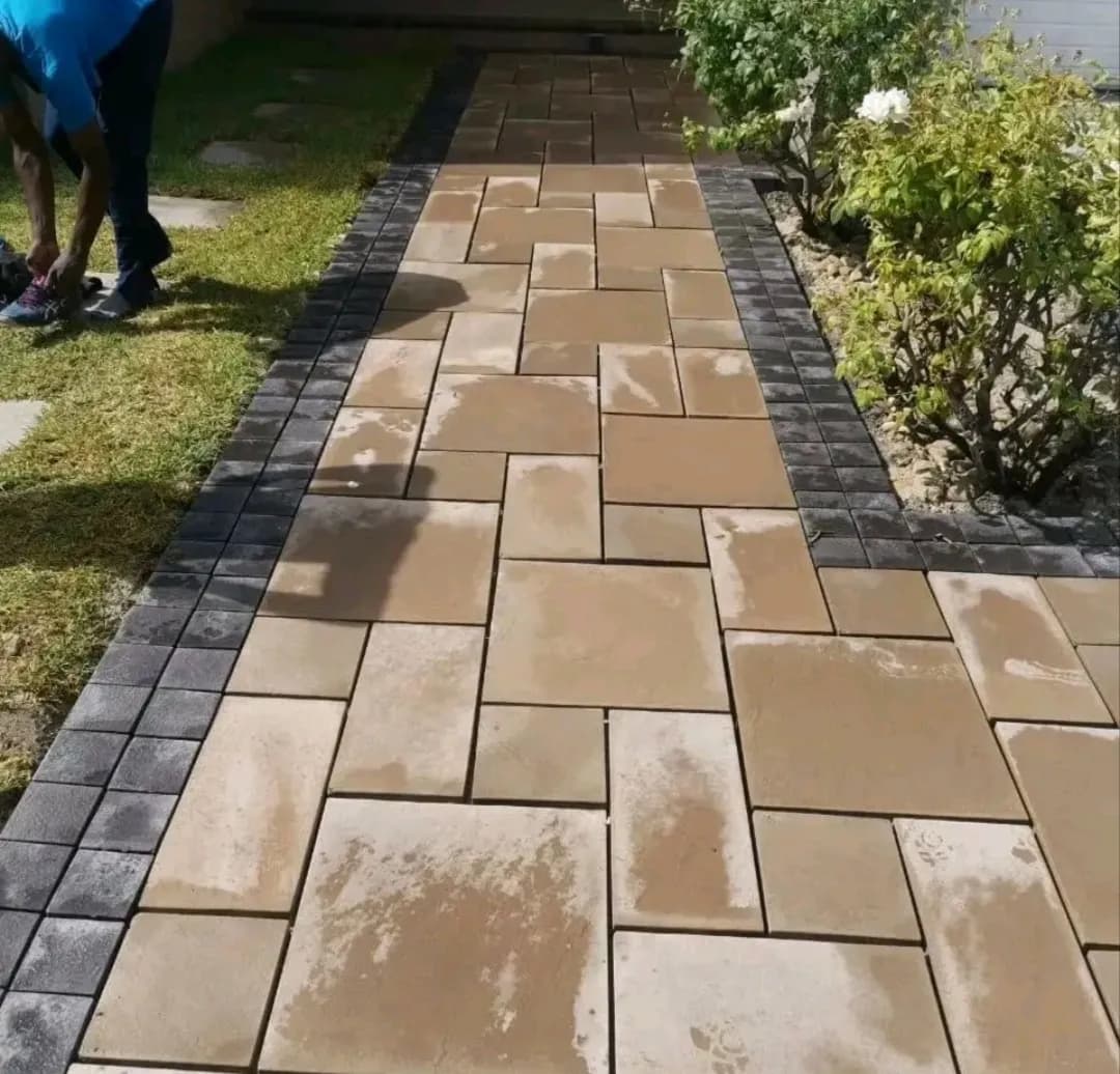 Garden path of large sandstone pavers with charcoal brick edging