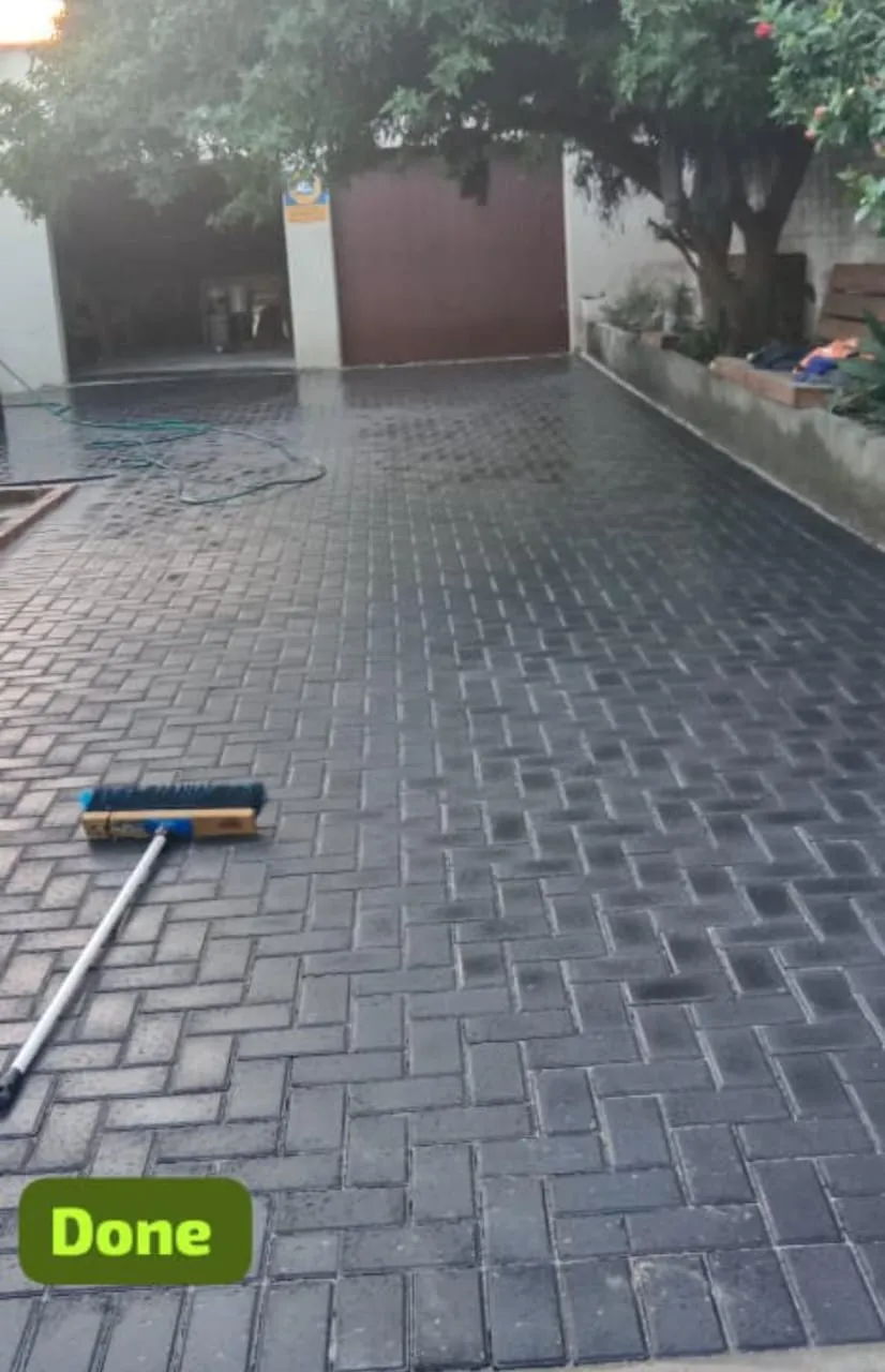 Charcoal herringbone paving being swept with sand