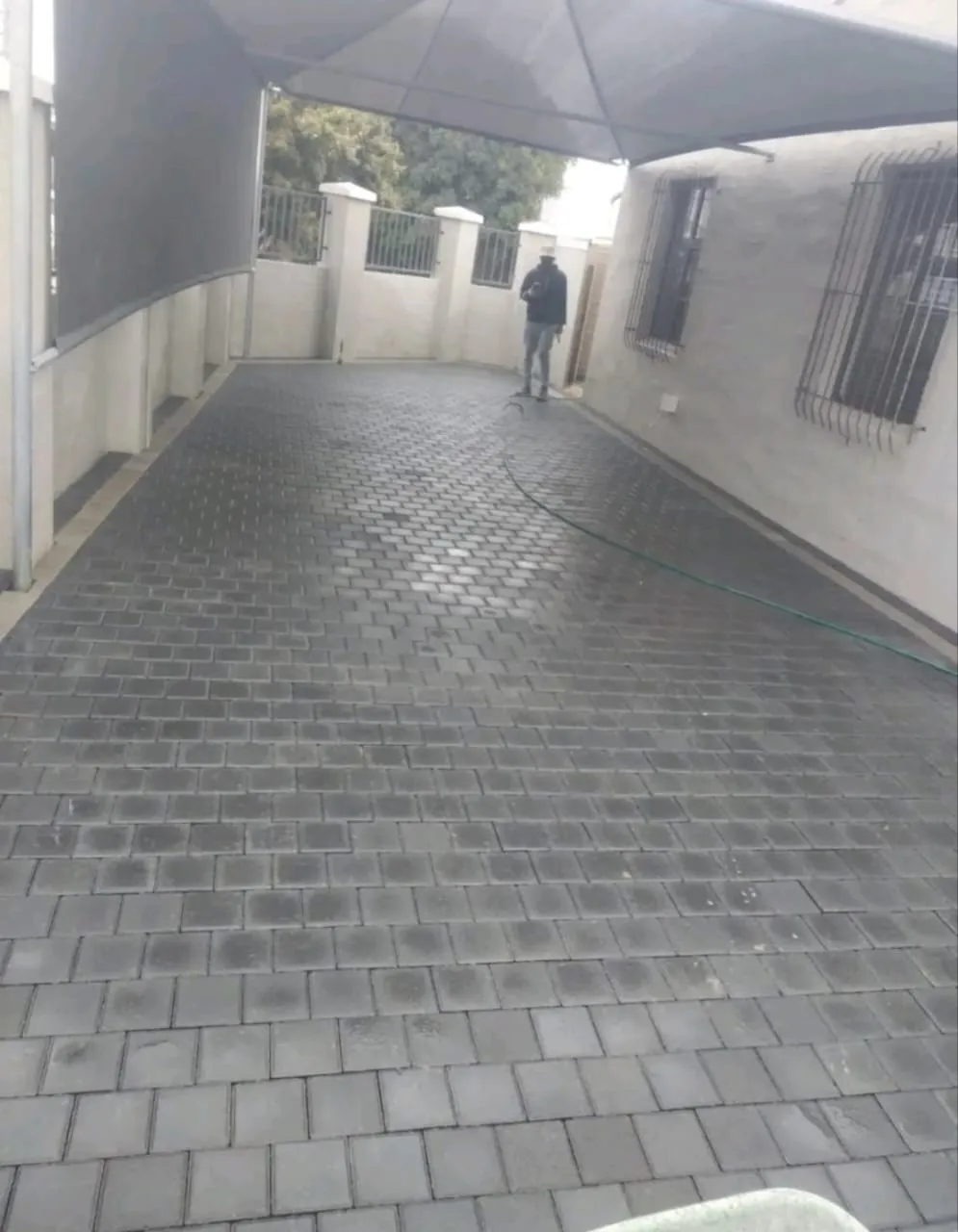 Charcoal paved driveway along a house