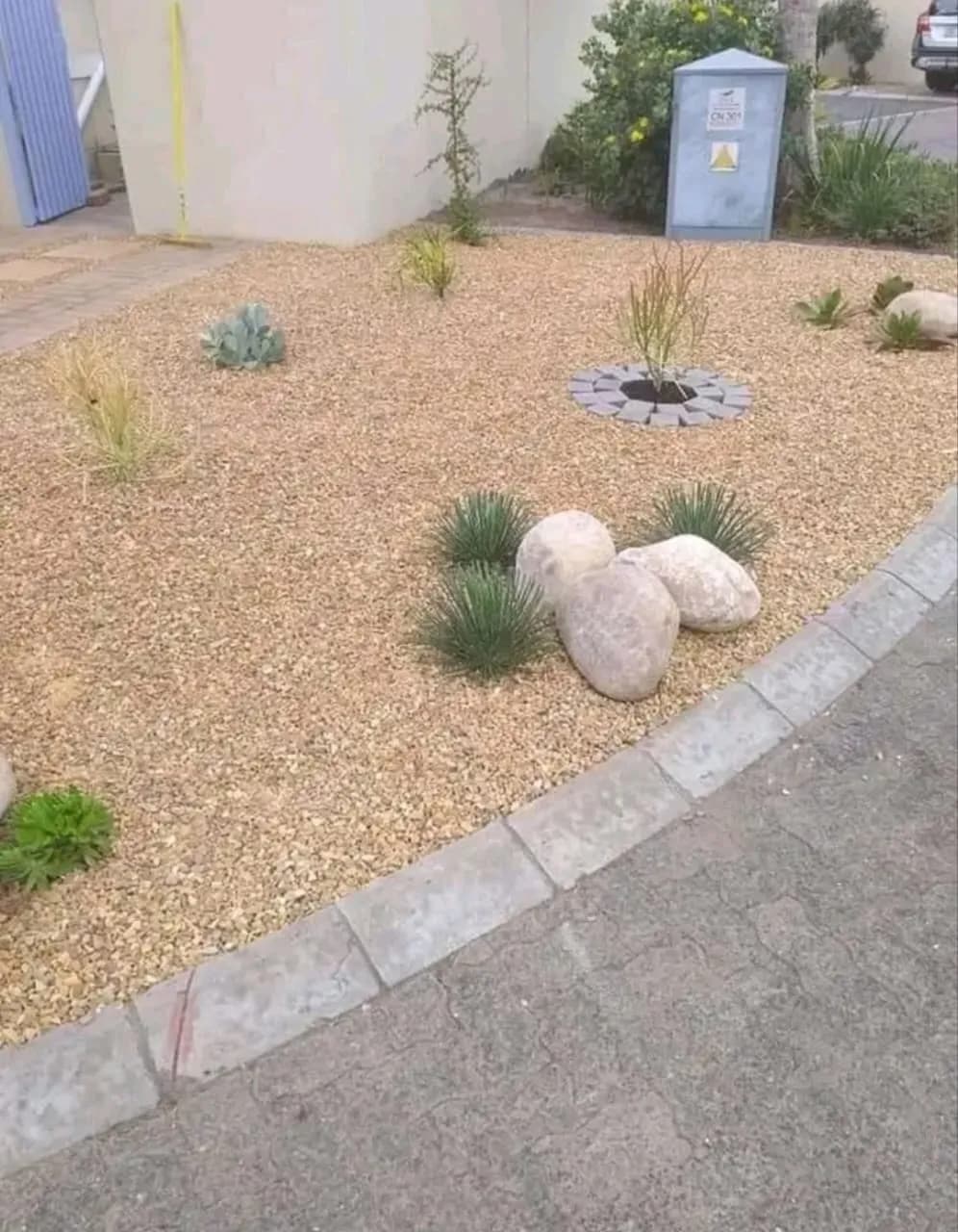 Brown pebble garden with boulders and grasses