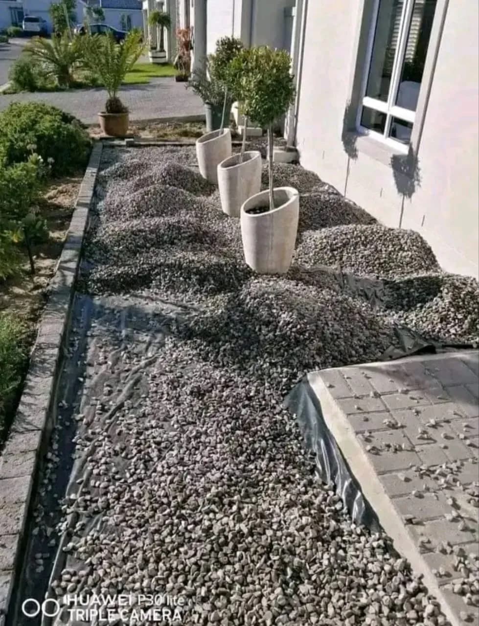 Grey stone being spread around planters